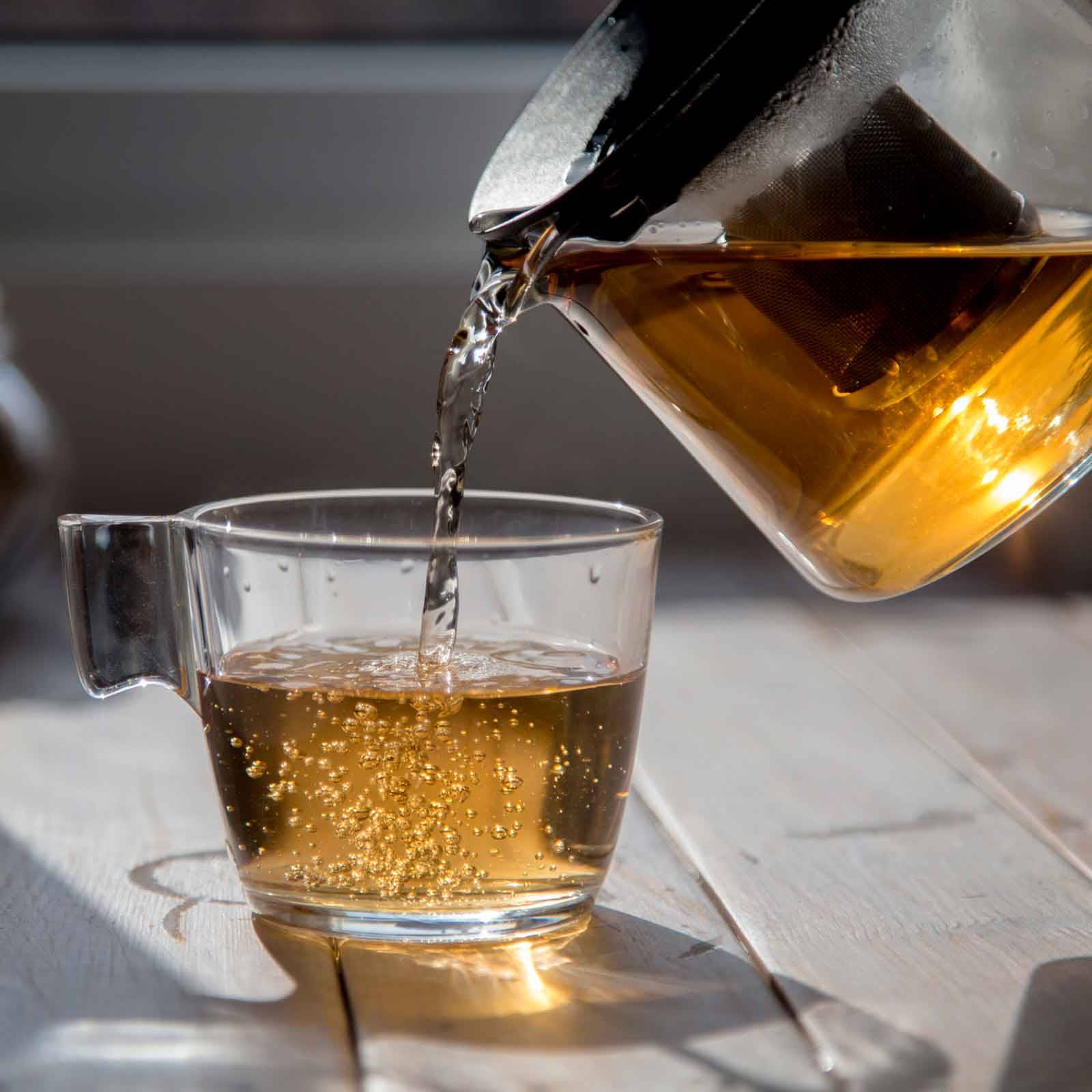 Dekoratives Bild mit aufgebrühtem Schwarztee Darjeeling Gold Star in einer Glastasse